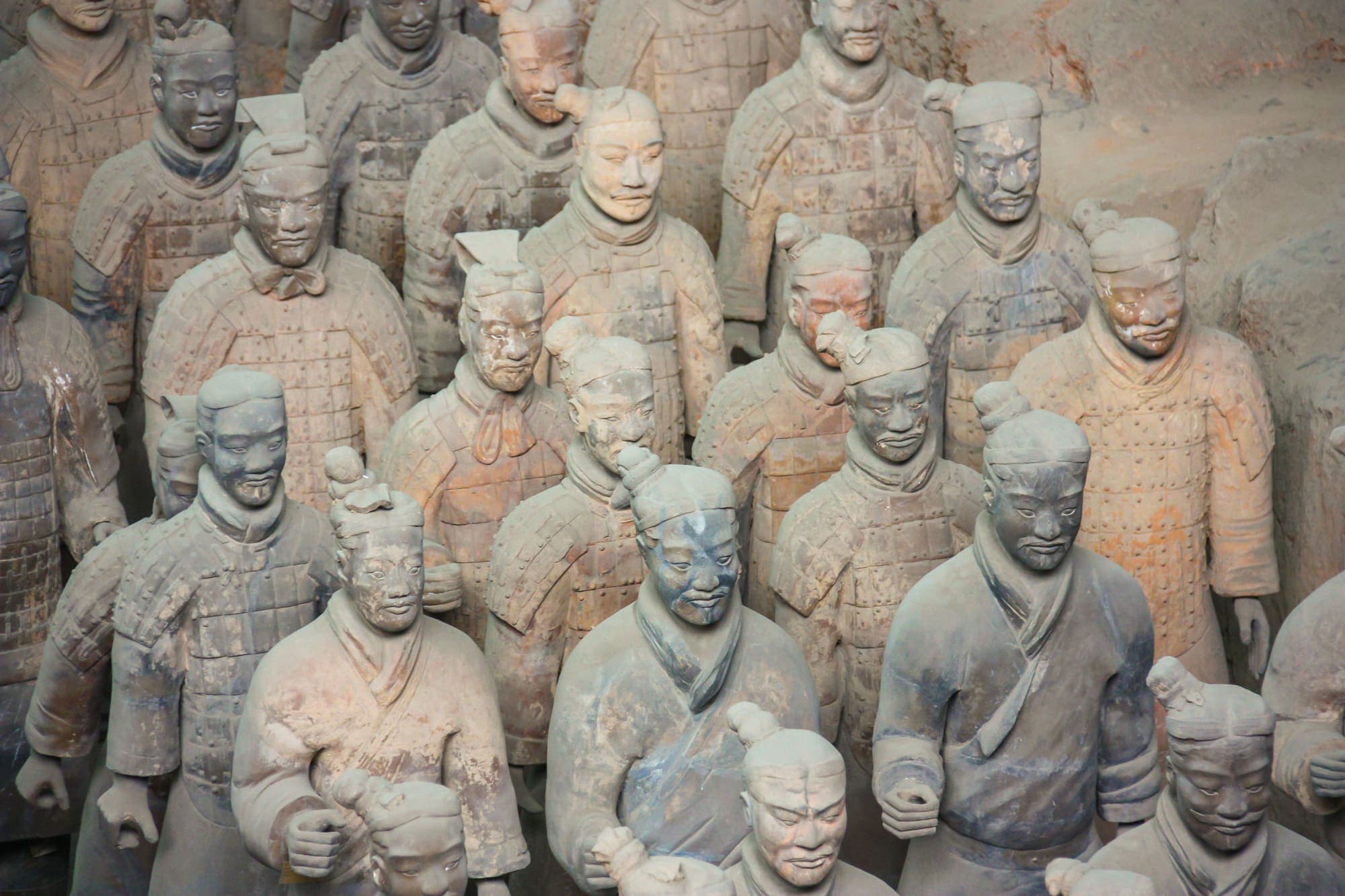 Estátuas dos Guerreiros de Terracota vistas de perto, cada uma com um rosto diferente.