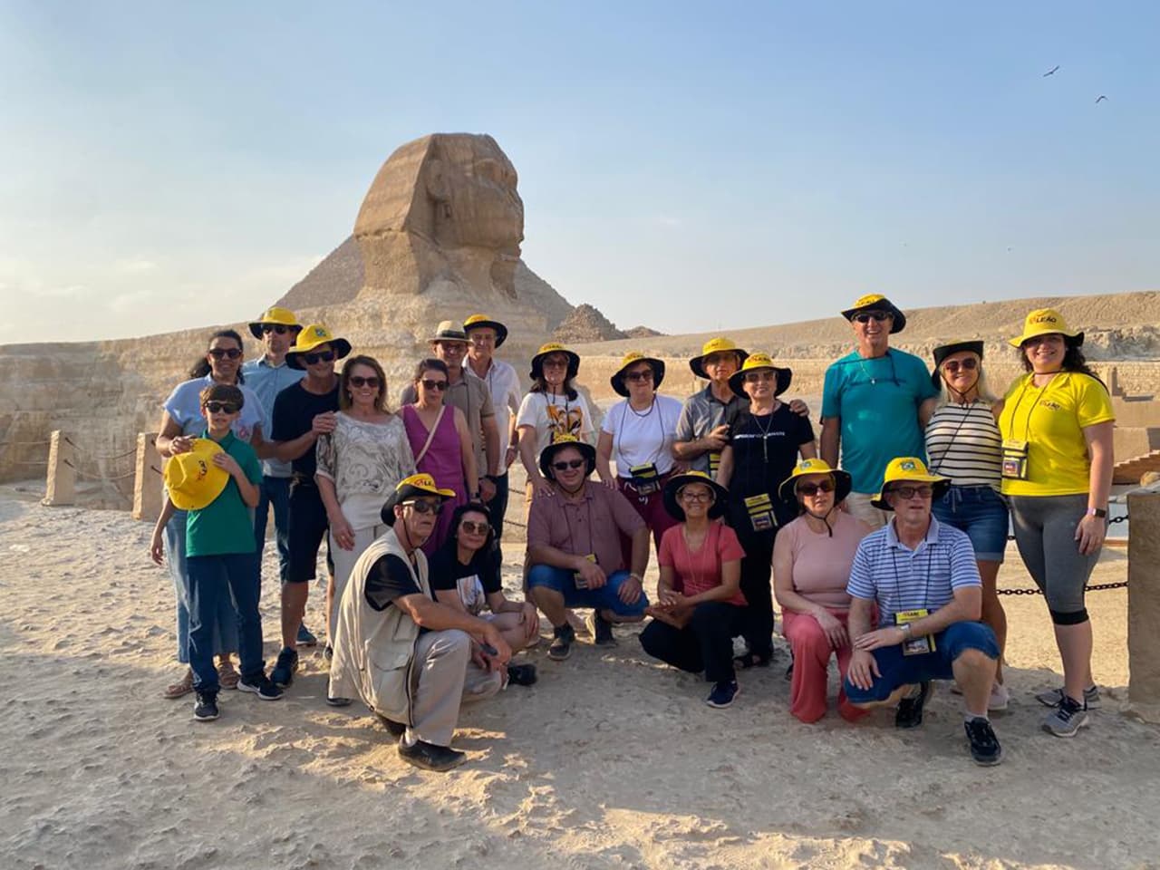 Grupo da Leão Viagens com os chapéus amarelos da Leão diante da Esfinge de Gizé.