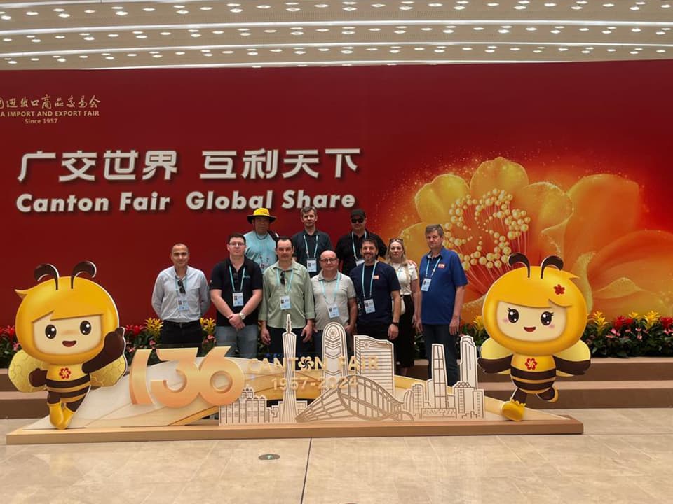 Grupo da Leão Viagens, de crachá, diante do painel de entrada da Canton Fair, na China.