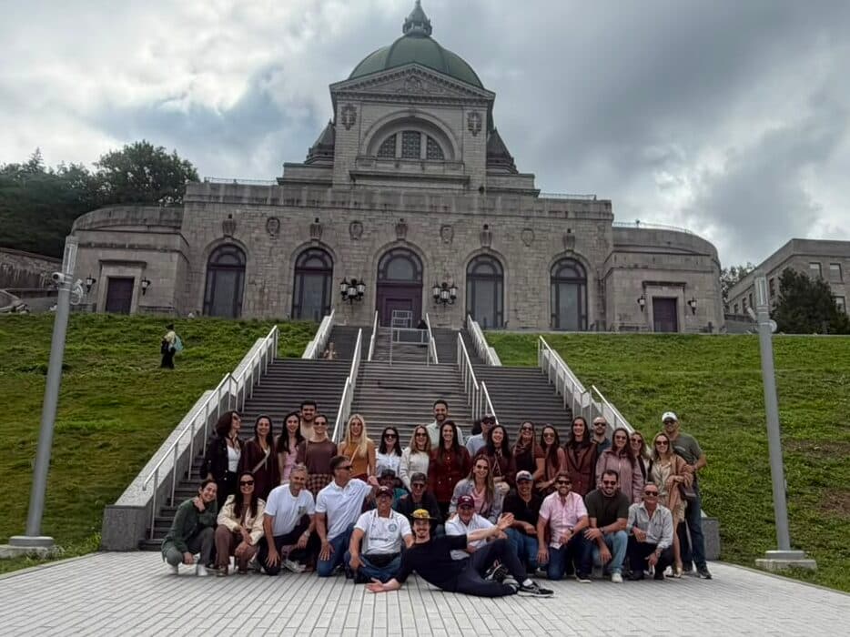 Grupo grande da Leão Viagens na escadaria diante de uma basílica de cúpula.